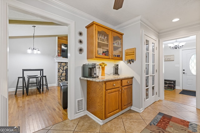 2421 Pittman Cir, Cumming, GA 30040 - bar featuring a chandelier, light tile patterned floors, ornamental molding, pendant lighting, and recessed lighting
