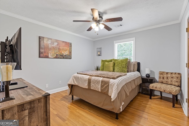 2421 Pittman Cir, Cumming, GA 30040 - bedroom with light wood-style flooring, ornamental molding, a textured ceiling, and a ceiling fan