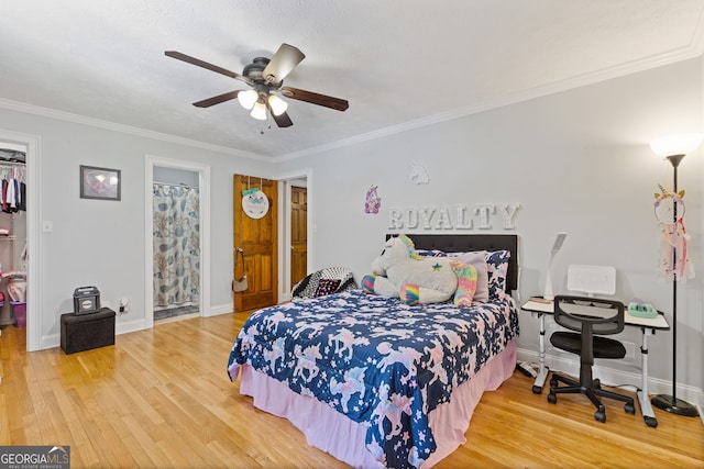2421 Pittman Cir, Cumming, GA 30040 - bedroom with wood finished floors, a walk in closet, crown molding, a closet, and ceiling fan