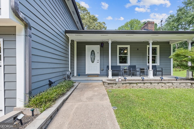 2421 Pittman Cir, Cumming, GA 30040 - view of exterior entry featuring a chimney, covered porch, and a lawn