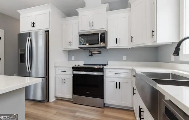 0 Nocona Trl, Ellijay, GA 30536 - kitchen featuring appliances with stainless steel finishes, white cabinetry, light wood-style flooring, and light countertops