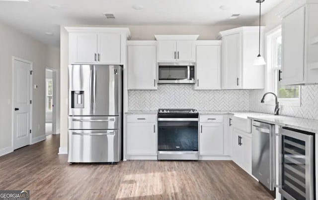 0 Nocona Trl, Ellijay, GA 30536 - kitchen with stainless steel appliances, beverage cooler, white cabinetry, tasteful backsplash, and wood finished floors