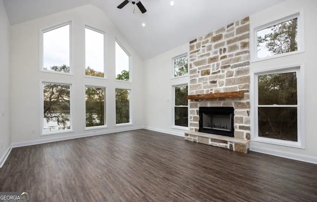 0 Nocona Trl, Ellijay, GA 30536 - unfurnished living room with high vaulted ceiling, a ceiling fan, a stone fireplace, and dark wood-type flooring