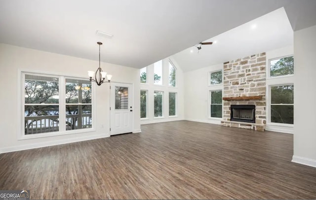 0 Nocona Trl, Ellijay, GA 30536 - unfurnished living room featuring a chandelier, dark wood finished floors, a stone fireplace, healthy amount of natural light, and vaulted ceiling
