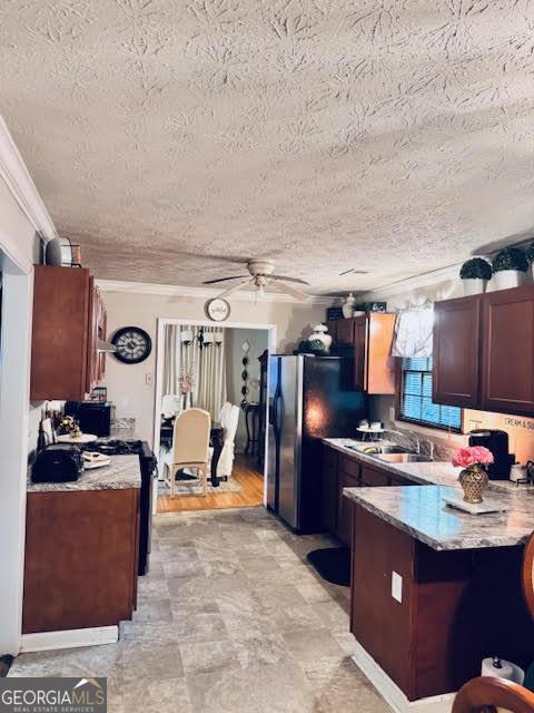 791 Bristol Way, Lithonia, GA 30058 - kitchen featuring a peninsula, a textured ceiling, crown molding, ceiling fan, and freestanding refrigerator