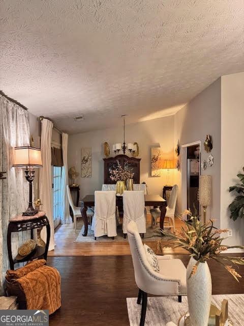791 Bristol Way, Lithonia, GA 30058 - dining space featuring a textured ceiling, wood finished floors, and a chandelier