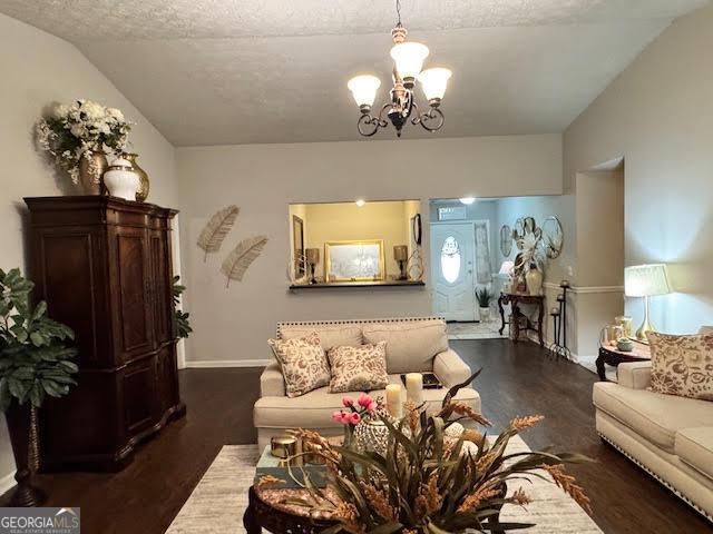 791 Bristol Way, Lithonia, GA 30058 - living room with a chandelier, dark wood-type flooring, a textured ceiling, and lofted ceiling