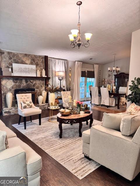 791 Bristol Way, Lithonia, GA 30058 - living room featuring a chandelier, wood finished floors, a textured ceiling, and a fireplace