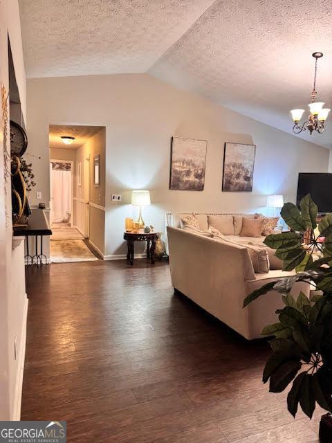 791 Bristol Way, Lithonia, GA 30058 - living room with vaulted ceiling, wood finished floors, a chandelier, and a textured ceiling