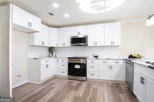 300 Saddle Creek Ln, Roswell, GA 30076 - kitchen with stainless steel appliances, light wood-style floors, decorative backsplash, light countertops, and recessed lighting