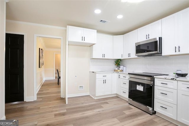 300 Saddle Creek Ln, Roswell, GA 30076 - kitchen featuring appliances with stainless steel finishes, crown molding, light countertops, light wood finished floors, and backsplash