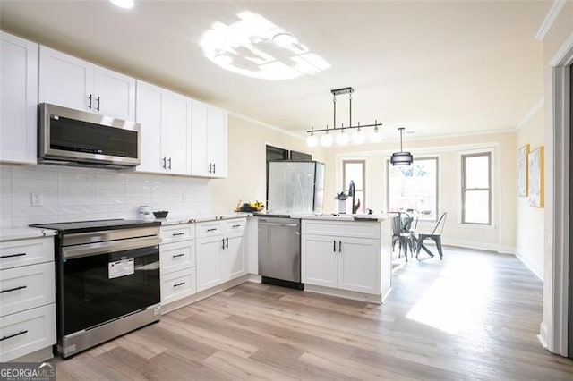 300 Saddle Creek Ln, Roswell, GA 30076 - kitchen with stainless steel appliances, ornamental molding, light wood-style flooring, white cabinets, and a peninsula
