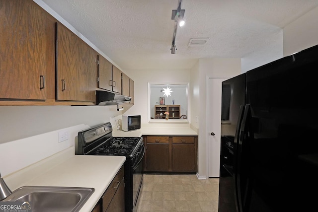 3907 Cedar Cir, Tucker, GA 30084 - kitchen with black appliances, track lighting, light countertops, under cabinet range hood, and a textured ceiling