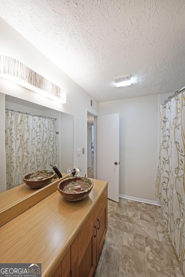 3907 Cedar Cir, Tucker, GA 30084 - full bath featuring vanity, a textured ceiling, and stone finish floors