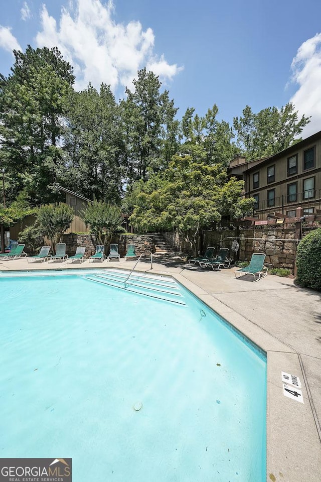 3907 Cedar Cir, Tucker, GA 30084 - community pool with a patio area and view of wooded area