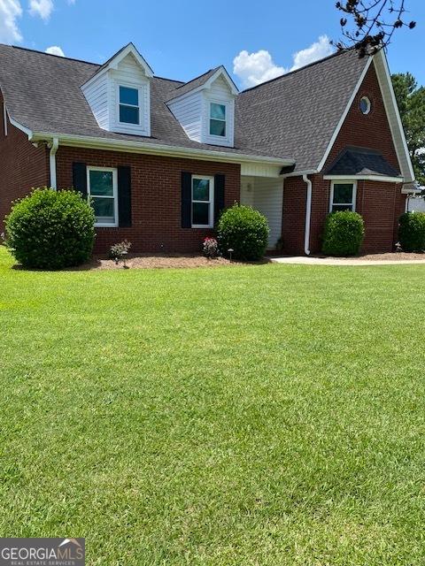 201 William D Evans Ct, Kathleen, GA 31047 - cape cod-style house featuring brick siding, a front yard, and a shingled roof