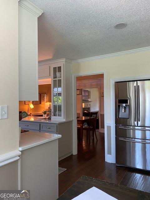 201 William D Evans Ct, Kathleen, GA 31047 - kitchen featuring stainless steel fridge with ice dispenser, a textured ceiling, dark wood-style flooring, white cabinetry, and glass insert cabinets