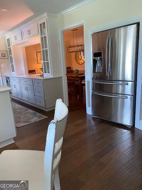 201 William D Evans Ct, Kathleen, GA 31047 - kitchen with stainless steel refrigerator with ice dispenser, glass insert cabinets, ornamental molding, light countertops, and dark wood-type flooring