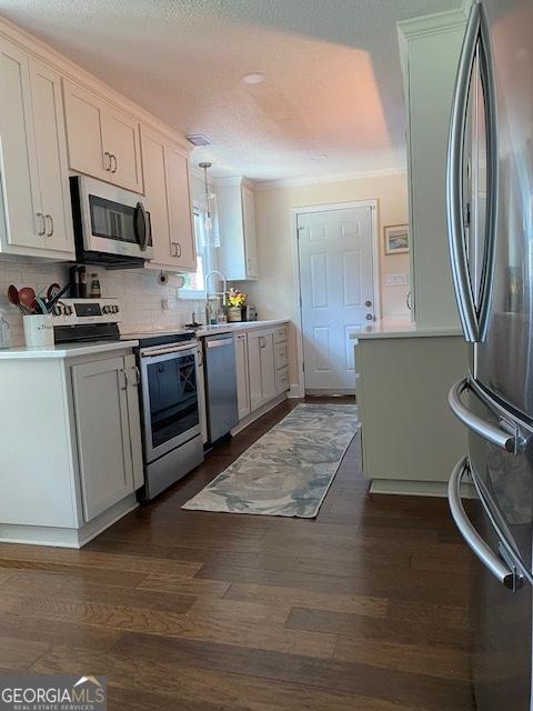 201 William D Evans Ct, Kathleen, GA 31047 - kitchen featuring stainless steel appliances, dark wood finished floors, light countertops, white cabinetry, and decorative backsplash