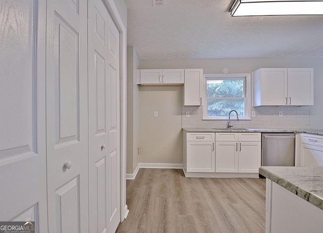 85 Holly Springs Rd, Sharpsburg, GA 30277 - kitchen with stainless steel dishwasher, light wood-type flooring, white cabinetry, decorative backsplash, and light stone countertops