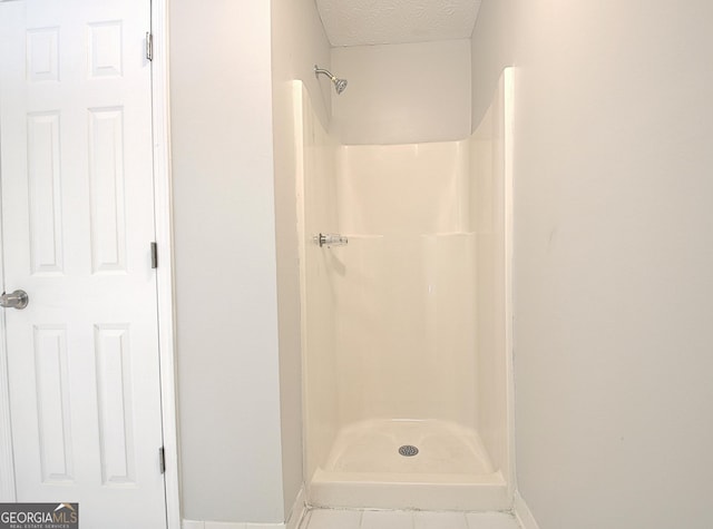85 Holly Springs Rd, Sharpsburg, GA 30277 - full bathroom featuring a shower, a textured ceiling, and tile patterned floors