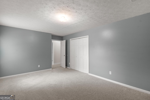 120 Bramble Bush Trl, Covington, GA 30014 - unfurnished bedroom featuring carpet flooring, a closet, and a textured ceiling
