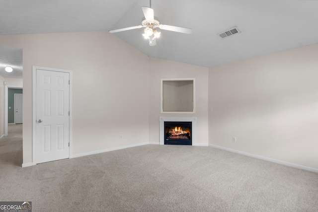 120 Bramble Bush Trl, Covington, GA 30014 - unfurnished living room with carpet flooring, a ceiling fan, lofted ceiling, and a warm lit fireplace