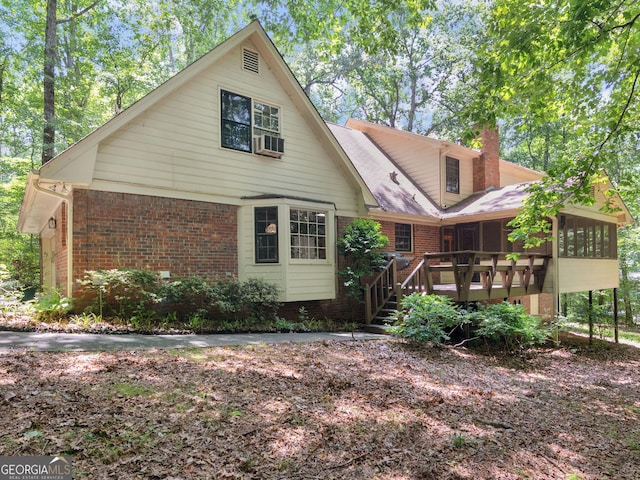 25 Ridgeview Dr, Jonesboro, GA 30236 - view of front facade with a sunroom, brick siding, a chimney, and a wooden deck