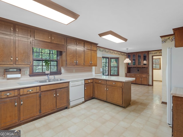 25 Ridgeview Dr, Jonesboro, GA 30236 - kitchen featuring light floors, white appliances, a peninsula, brown cabinetry, and light countertops