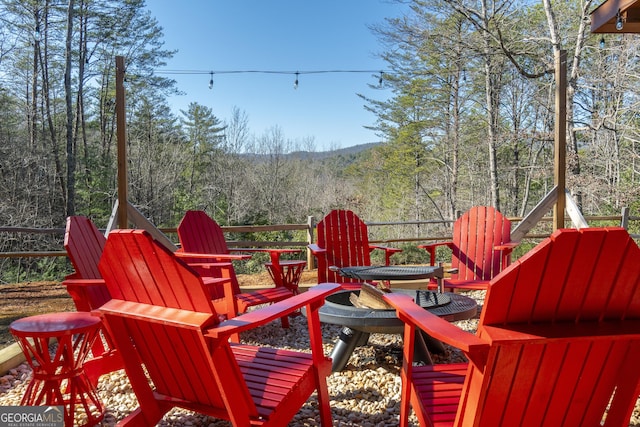 444 Miners Mountain Rd, Sautee Nacoochee, GA 30571 - wooden terrace featuring an outdoor fire pit and a view of trees