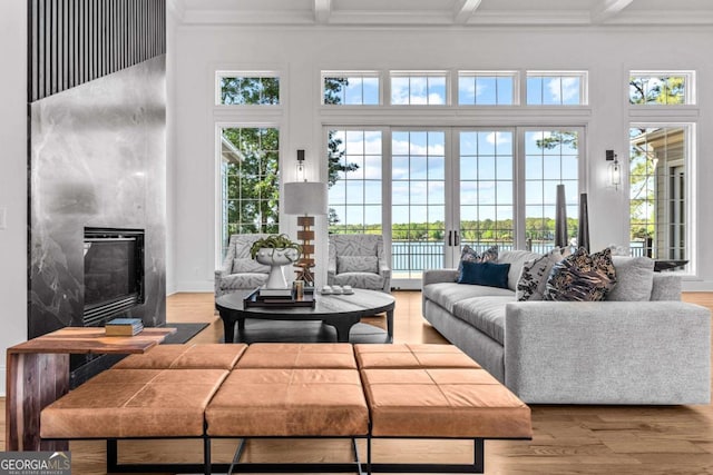 1230 Lake Club Dr, Greensboro, GA 30642 - living area with plenty of natural light, beamed ceiling, a glass covered fireplace, a high ceiling, and crown molding