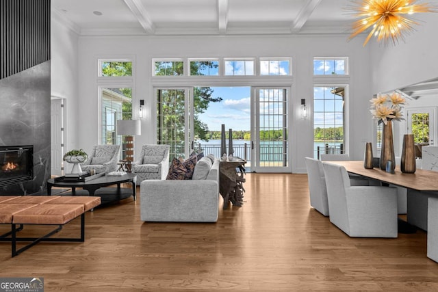 1230 Lake Club Dr, Greensboro, GA 30642 - living area with beamed ceiling, a high ceiling, a fireplace, light wood-style flooring, and a water view