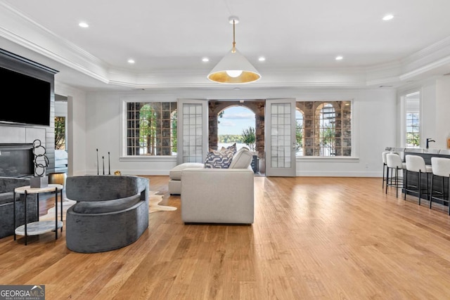 1230 Lake Club Dr, Greensboro, GA 30642 - living area with a raised ceiling, ornamental molding, light wood-style flooring, a tile fireplace, and plenty of natural light