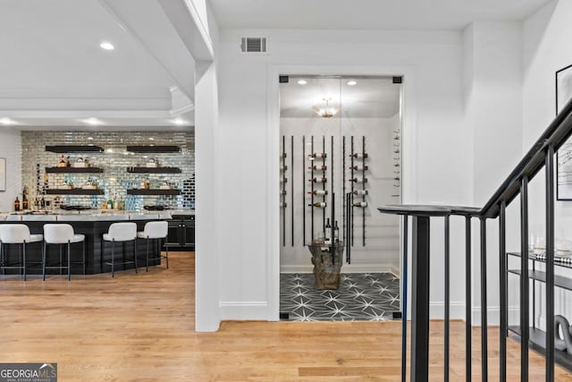 1230 Lake Club Dr, Greensboro, GA 30642 - wine cellar featuring light wood-style flooring, bar with sink, and recessed lighting