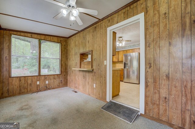 6111 Old Monticello St SE, Covington, GA 30014 - carpeted spare room featuring a ceiling fan, wooden walls, and ornamental molding