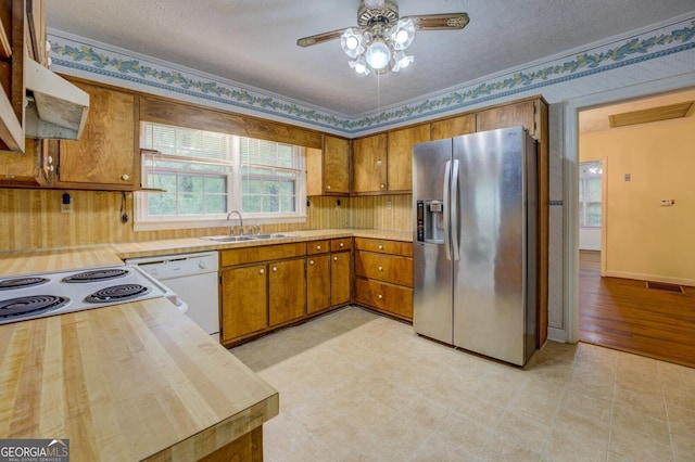 6111 Old Monticello St SE, Covington, GA 30014 - kitchen featuring stainless steel fridge, white dishwasher, brown cabinets, a ceiling fan, and a textured ceiling
