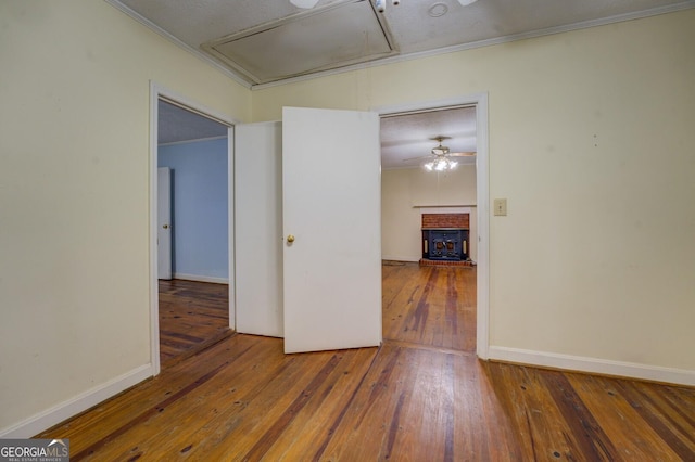 6111 Old Monticello St SE, Covington, GA 30014 - empty room featuring attic access, hardwood / wood-style flooring, and ornamental molding