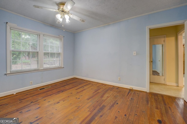6111 Old Monticello St SE, Covington, GA 30014 - unfurnished room featuring a textured ceiling, crown molding, hardwood / wood-style floors, and a ceiling fan