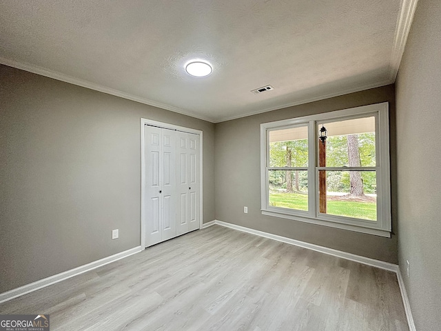 115 Creekside Ln, Covington, GA 30016 - unfurnished bedroom with wood finished floors, crown molding, a textured ceiling, and a closet