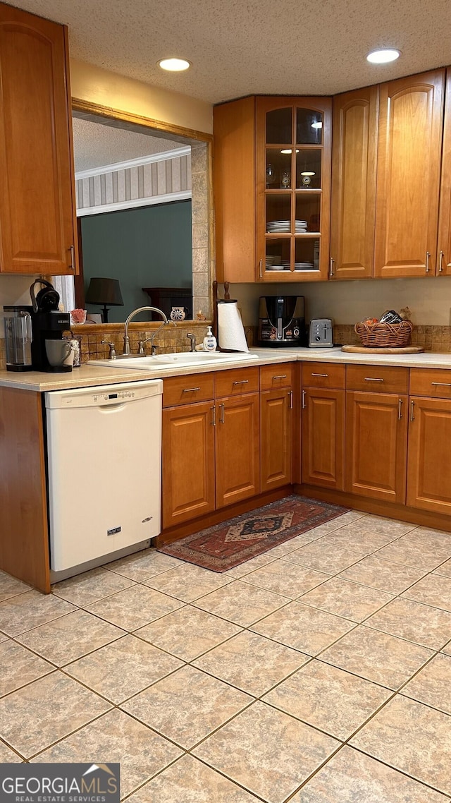 5904 Clairmont Way, Powder Springs, GA 30127 - kitchen featuring white dishwasher, light countertops, brown cabinets, glass insert cabinets, and recessed lighting