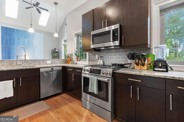 1903 Anjaco Rd NW Unit 5, Atlanta, GA 30309 - kitchen featuring appliances with stainless steel finishes, a skylight, tasteful backsplash, light wood-style floors, and lofted ceiling