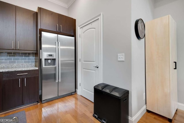 1903 Anjaco Rd NW Unit 5, Atlanta, GA 30309 - kitchen featuring built in refrigerator, crown molding, light wood-type flooring, dark brown cabinets, and decorative backsplash