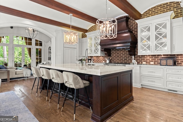 4874 Kettle River Pt, Suwanee, GA 30024 - kitchen featuring a chandelier, white cabinetry, a kitchen breakfast bar, and a large island with sink