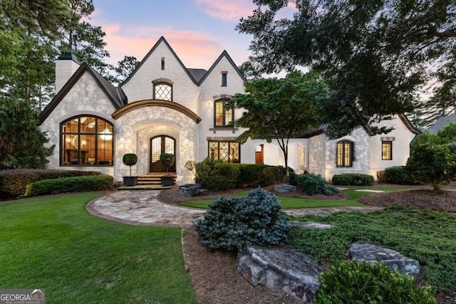 4874 Kettle River Pt, Suwanee, GA 30024 - french country inspired facade with stone siding, a front lawn, a chimney, and french doors