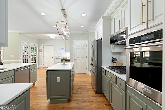 3095 Chattahoochee Trce, Gainesville, GA 30506 - kitchen with gray cabinets, appliances with stainless steel finishes, a center island, ornamental molding, and light wood finished floors