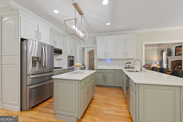 3095 Chattahoochee Trce, Gainesville, GA 30506 - kitchen with appliances with stainless steel finishes, crown molding, a peninsula, light countertops, and a kitchen island