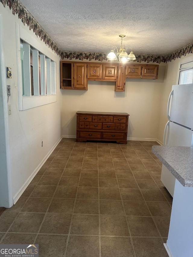 421 Chase Cir, Cornelia, GA 30531 - kitchen featuring a textured ceiling, a chandelier, freestanding refrigerator, dark tile patterned flooring, and hanging light fixtures
