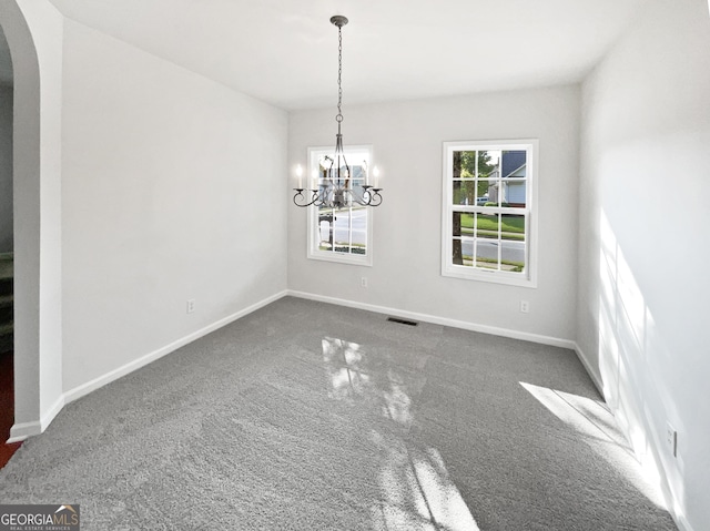 2438 Suwanee Pointe Dr, Lawrenceville, GA 30043 - unfurnished dining area with arched walkways, carpet flooring, and a chandelier