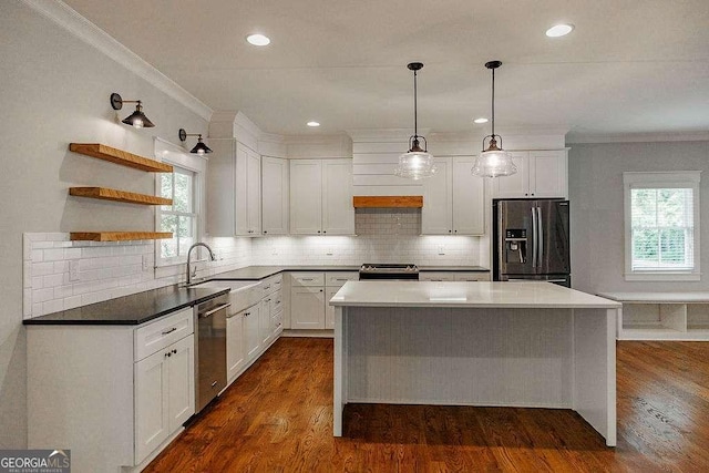 175 Pinecrest Ct, Athens, GA 30605 - kitchen featuring appliances with stainless steel finishes, crown molding, a kitchen island, dark wood-type flooring, and white cabinetry