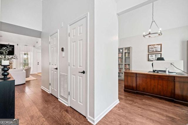 1825 Millstone Ct, Alpharetta, GA 30004 - corridor featuring high vaulted ceiling, wood finished floors, a chandelier, and a desk
